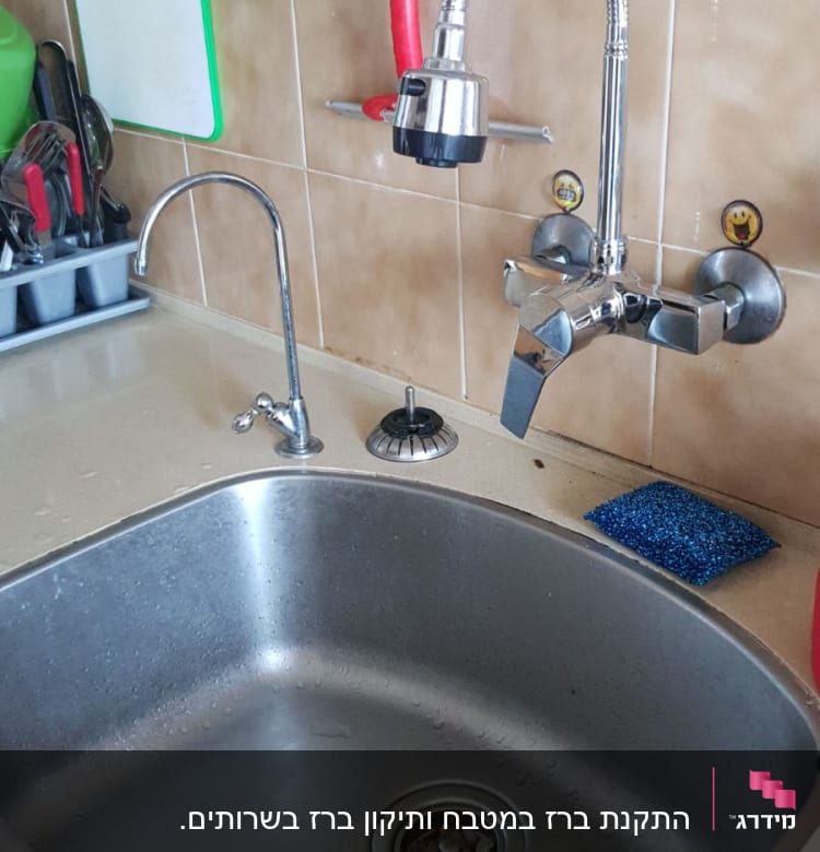 ברז נירוסטה עם צינור גמיש מעל כיור מטבח